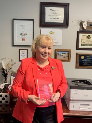 Tina Nicholson holding 2020 Business Professional Woman of the Year Award